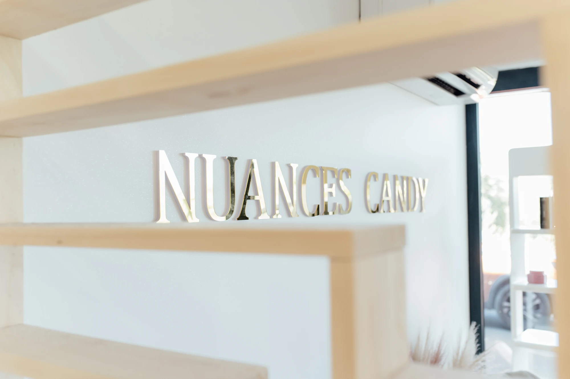 Enseigne dorée Nuances Candy dans le salon
